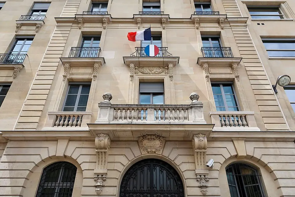 Façade du ministère de l'éducation nationale, orné de drapeaux tricolore, symbolisant l'institution scolaire et les politiques publiques